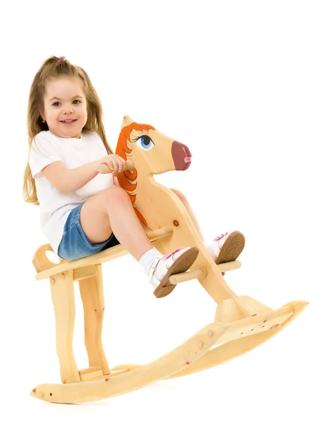 Dívka, houpání na dřevěného koně. — Stock fotografie
