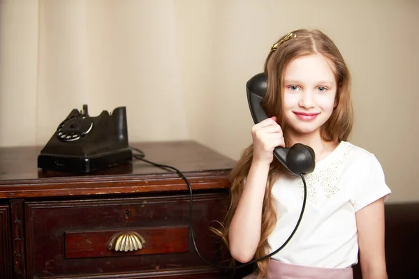 Seorang gadis kecil berdering di telepon lama. — Stok Foto