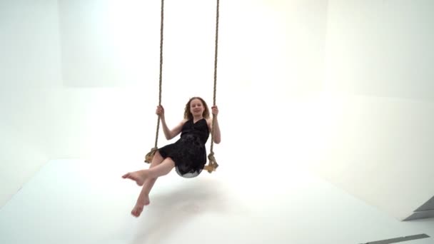 A little girl is swinging on a swing with a teddy bear. — Stock Video