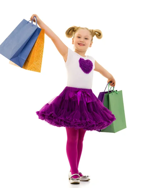 Menina com sacos multicoloridos em suas mãos. — Fotografia de Stock