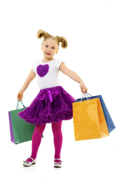 Little girl with multi-colored bags in their hands. — Stock Photo, Image