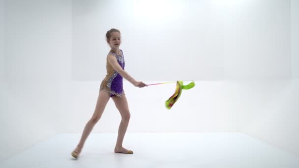 Kız jimnastikçi alıştırmaları bant ile yapıyor. — Stok video
