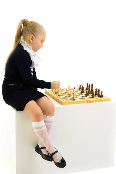 Uma menina a jogar xadrez. Isolado sobre fundo branco — Fotografia de Stock