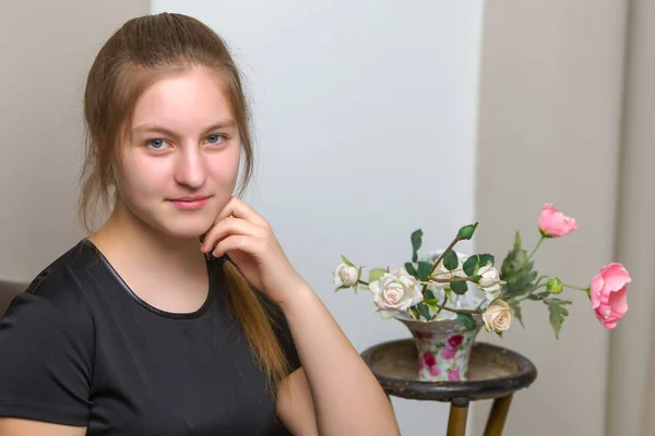 Linda menina adolescente olha para um buquê de flores — Fotografia de Stock