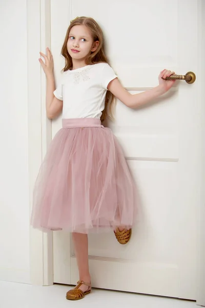 Una niña está parada junto a la puerta. . —  Fotos de Stock
