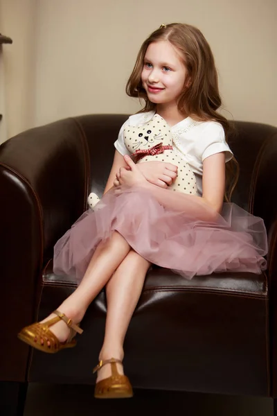 Little girl is sitting on the couch — Stock Photo, Image