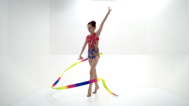 Een meisje gymnast voert oefeningen met een knots. — Stockvideo