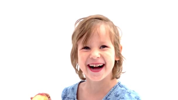 Niña alegre comiendo una manzana, concepto de alimentación saludable . — Vídeo de stock