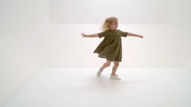 Ein kleines Mädchen im Kleid dreht sich. — Stockvideo