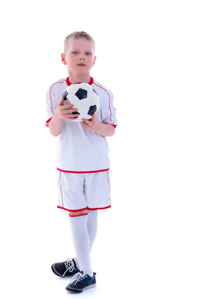 Ένα μικρό αγόρι που φοράει ένα καθαρό λευκό t-shirt παίζει με ένα ποδοσφαίρου — Φωτογραφία Αρχείου