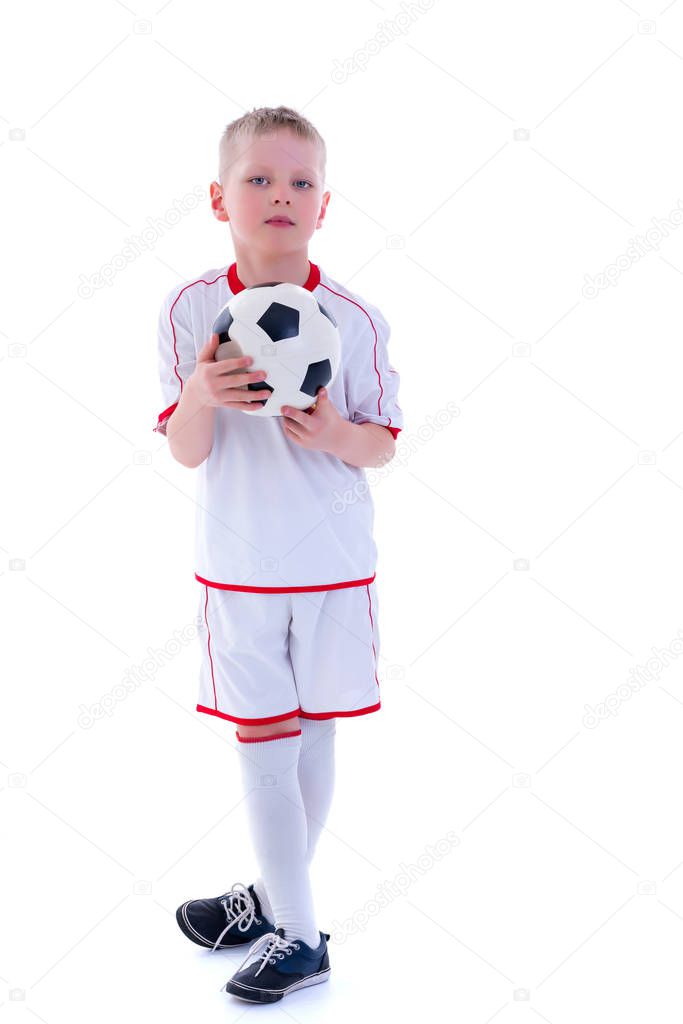 A little boy wearing a pure white t-shirt is playing with a socc