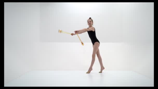 Uma ginasta menina executa exercícios com uma maça. — Vídeo de Stock