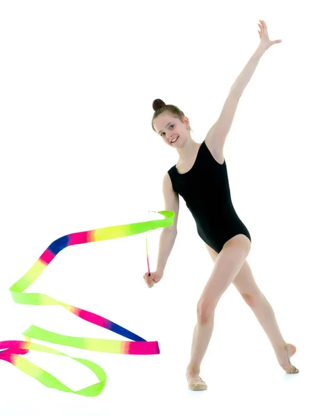 Девушка гимнастка выполняет упражнения с лентой. — стоковое фото