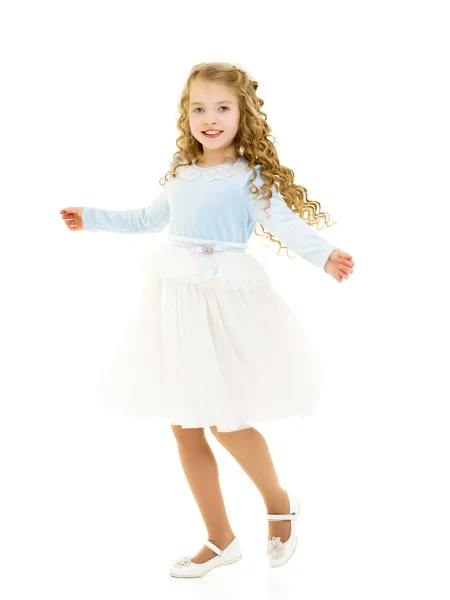 Een klein meisje in een jurk draait.. — Stockfoto