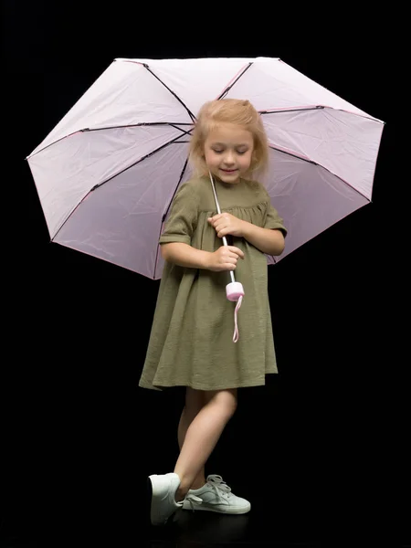 Kleines Mädchen unter einem Regenschirm. Schutz vor schlechtem Wetter. — Stockfoto