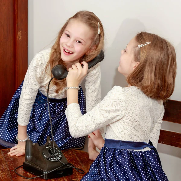 Dua saudara perempuan berbicara di telepon lama — Stok Foto