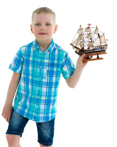 Um menino está brincando com um barco . — Fotografia de Stock