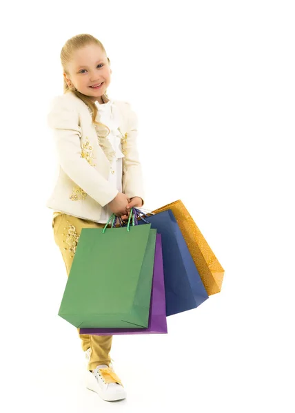 Little girl with multi-colored bags in their hands. — Stock Photo, Image