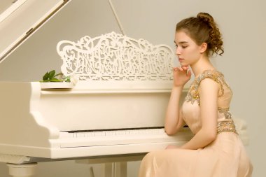 Kız beyaz piyanonun başında..