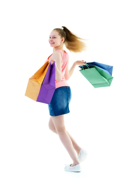 Маленька дівчинка з різнокольоровими сумками в руках . — стокове фото