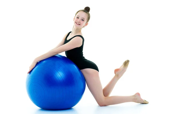 Fetiță face exerciții pe o minge mare pentru fitness . — Fotografie, imagine de stoc