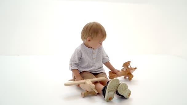 Kleine jongen spelen met houten vliegtuig — Stockvideo