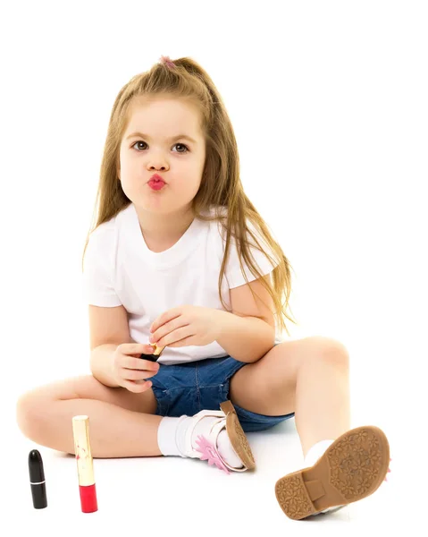 Niña pinta los labios con lápiz labial de las mamás . — Foto de Stock