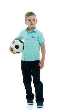 Küçük çocuk bir futbol topuyla oynuyor.