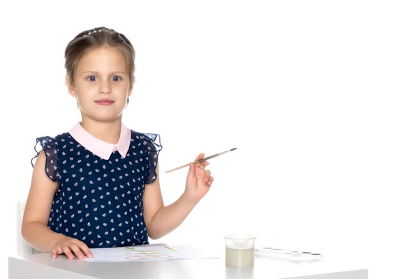 Ein kleines Mädchen malt mit Farbe und Pinsel. — Stockfoto