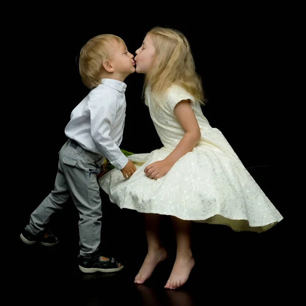 Uma menina e um menino, irmão e irmã, beijar uns aos outros no stu — Fotografia de Stock