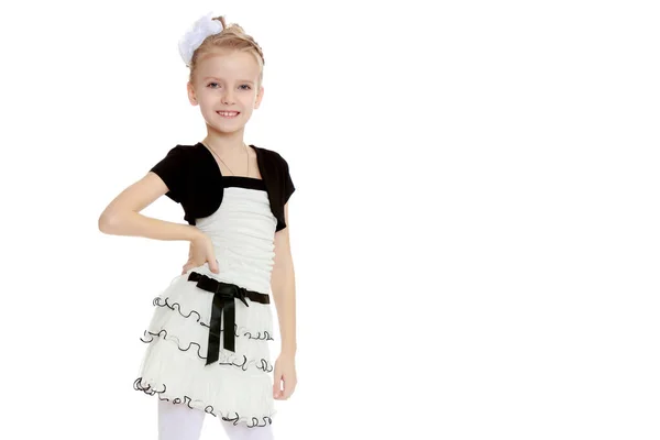 Schönes kleines Mädchen in einem weißen kurzen Kleid mit schwarzem Gürtel. — Stockfoto
