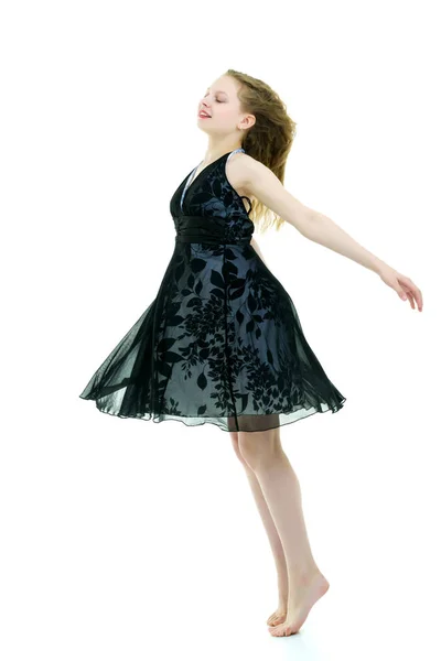 Liten flicka i en klänning som utvecklas i vinden. Stockfoto
