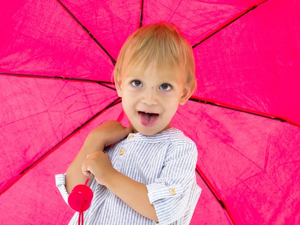 En söt liten pojke tog sin tillflykt under ett paraply. Koncept spel, h — Stockfoto