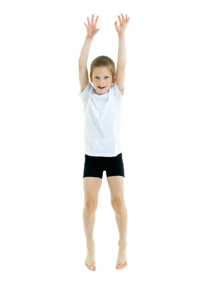 Un petit garçon dans un t-shirt blanc propre saute d'amusement . — Photo