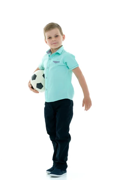 Menino está jogando com uma bola de futebol . — Fotografia de Stock