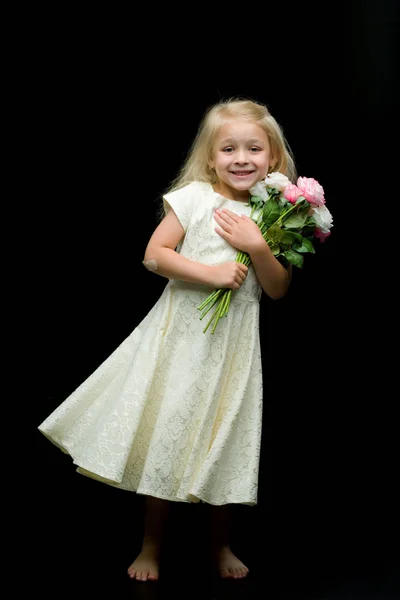 Kleines Mädchen mit einem Blumenstrauß auf schwarzem Hintergrund. — Stockfoto