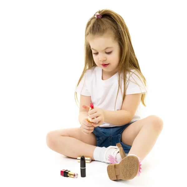 Little girl paints lips with moms lipstick. — Stock Photo, Image
