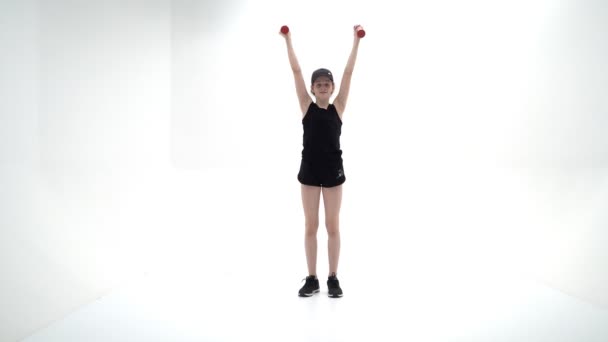 Tinédzser lány súlyzókkal a kezében — Stock videók