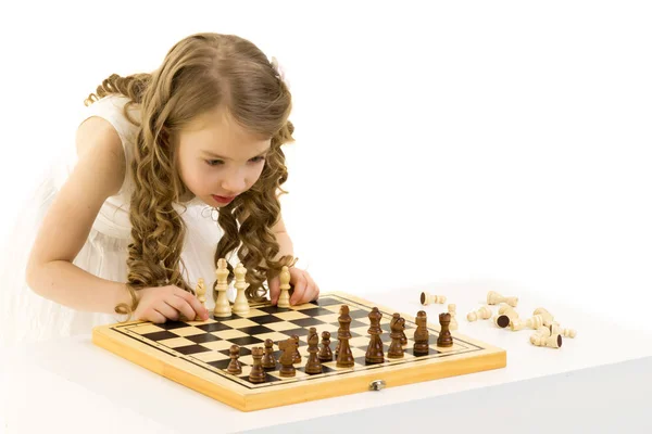 Mała dziewczynka gra w szachy. Izolowane na białym tle — Zdjęcie stockowe