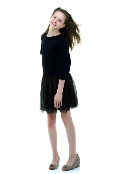 Krásná holčička stojí ve větru, její vlasy a šaty — Stock fotografie