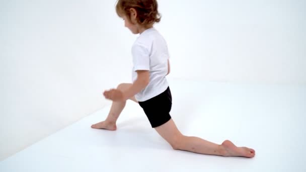 Очаровательная маленькая девочка делает гимнастические упражнения в студии на — стоковое видео
