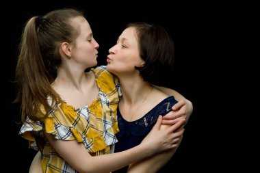 Anne ve küçük kız stüdyo resmi. Siyah arka planda.