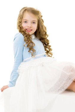 Küçük kız beyaz bir pankartta oturuyor..