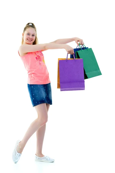 Маленька дівчинка з різнокольоровими сумками в руках . — стокове фото