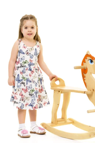 Girl swinging on a wooden horse. — Stock Photo, Image