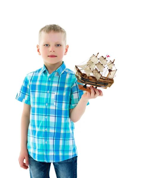 Um menino está brincando com um barco . — Fotografia de Stock