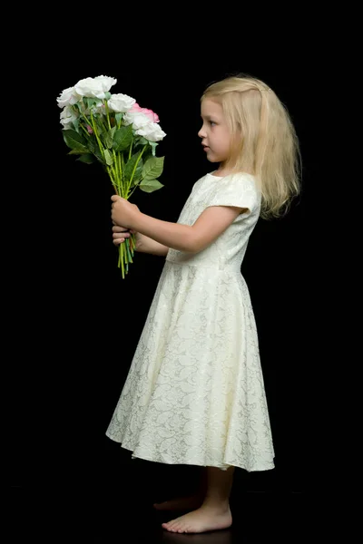 Meisje met een boeket bloemen op een zwarte achtergrond. — Stockfoto