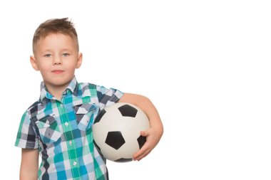 Küçük çocuk bir futbol topuyla oynuyor.