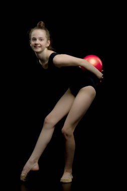 Kız jimnastikçi, topla egzersiz yapıyor..