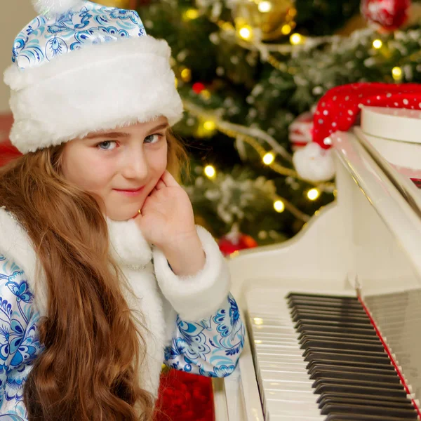 पियानो आणि ख्रिसमस ट्री जवळ लहान मुलगी . — स्टॉक फोटो, इमेज